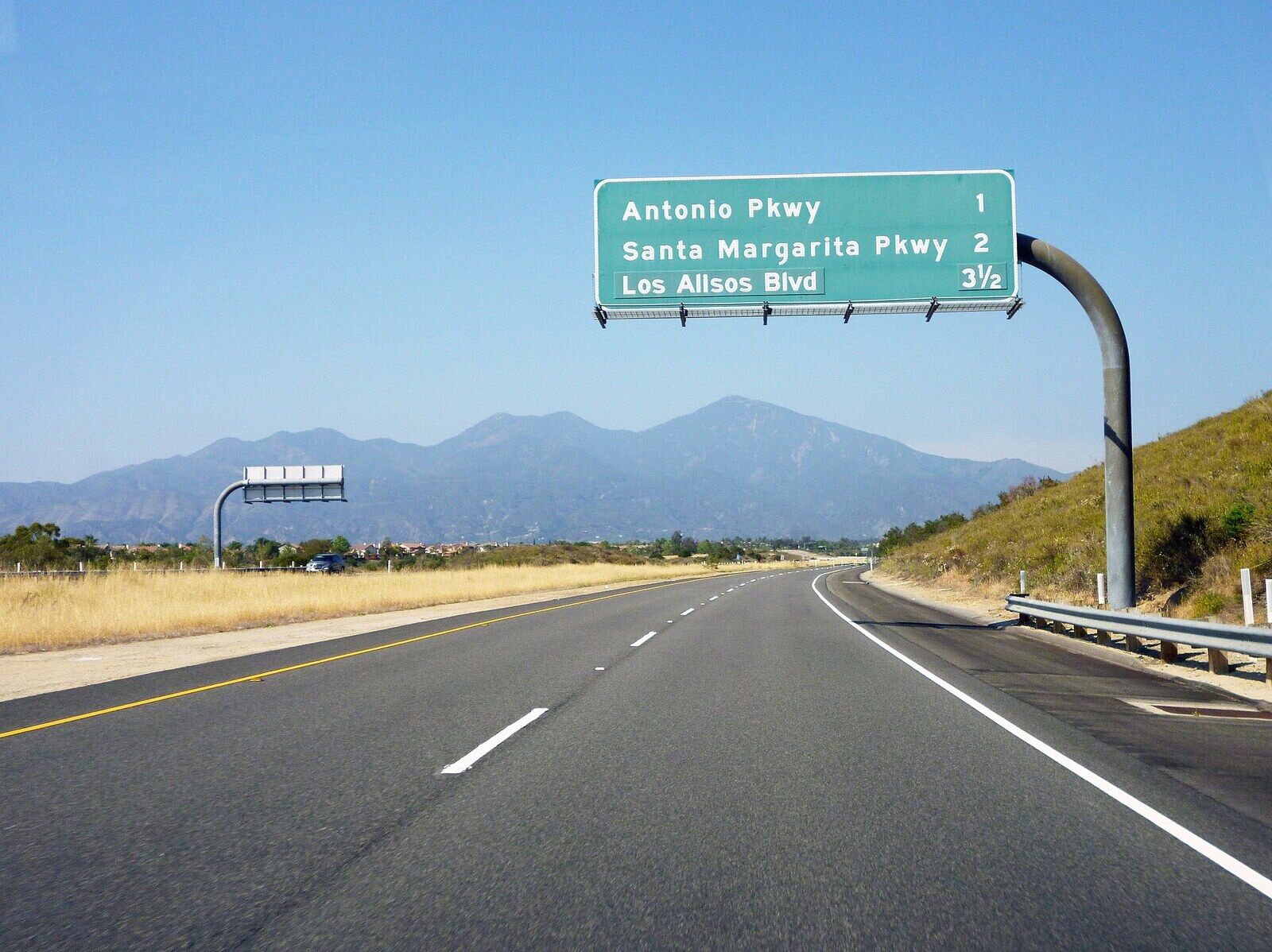 The 241 toll road a mile before the Antonio Parkway exit, with Saddleback ahead and dry grass hills